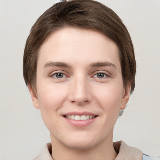 Joyful white young-adult female with short  brown hair and grey eyes