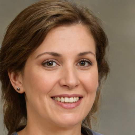 Joyful white adult female with medium  brown hair and brown eyes