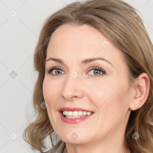 Joyful white young-adult female with long  brown hair and blue eyes