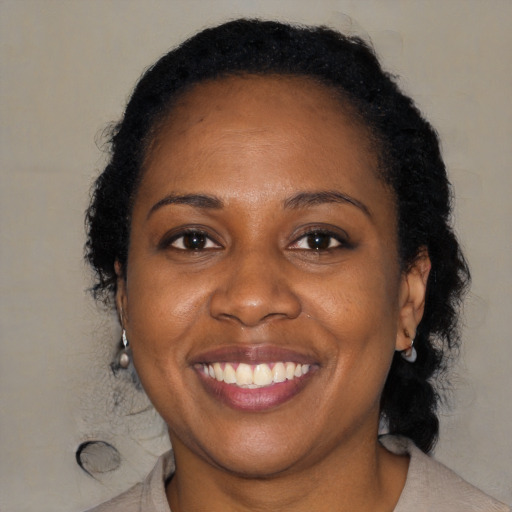 Joyful black adult female with medium  brown hair and brown eyes