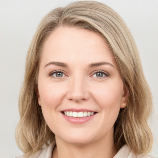 Joyful white young-adult female with medium  brown hair and green eyes