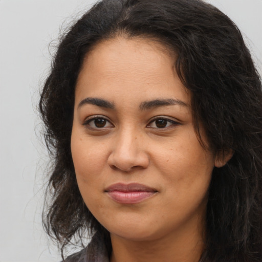 Joyful latino young-adult female with long  brown hair and brown eyes