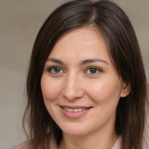 Joyful white young-adult female with long  brown hair and brown eyes