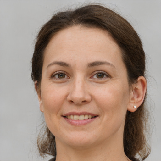 Joyful white young-adult female with medium  brown hair and grey eyes