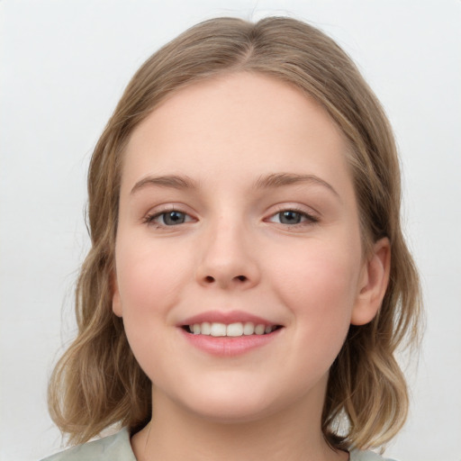 Joyful white child female with medium  brown hair and grey eyes