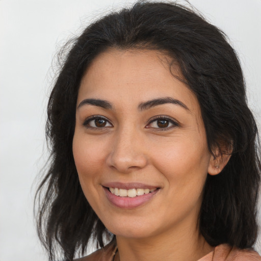 Joyful latino young-adult female with long  brown hair and brown eyes