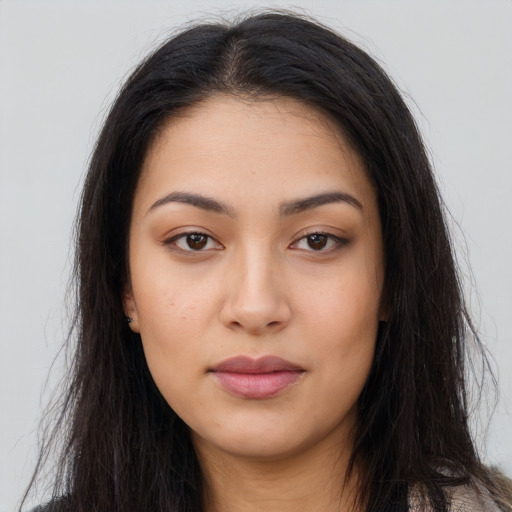 Joyful latino young-adult female with long  brown hair and brown eyes