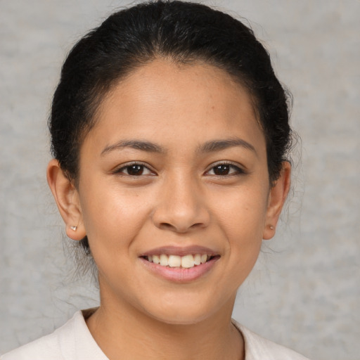 Joyful latino young-adult female with short  brown hair and brown eyes