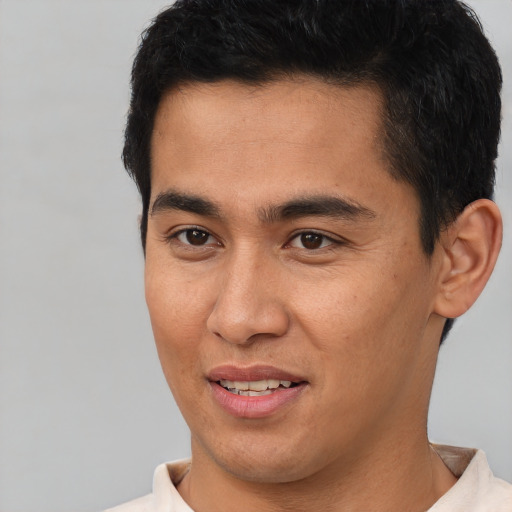 Joyful latino young-adult male with short  brown hair and brown eyes