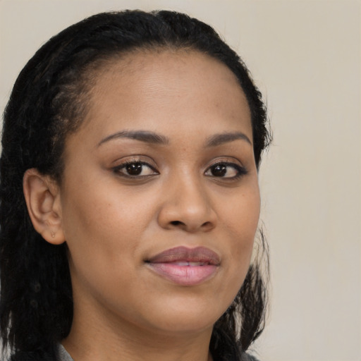 Joyful black young-adult female with long  brown hair and brown eyes