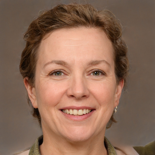 Joyful white adult female with medium  brown hair and green eyes