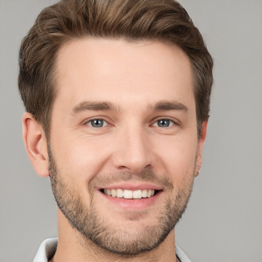 Joyful white young-adult male with short  brown hair and grey eyes