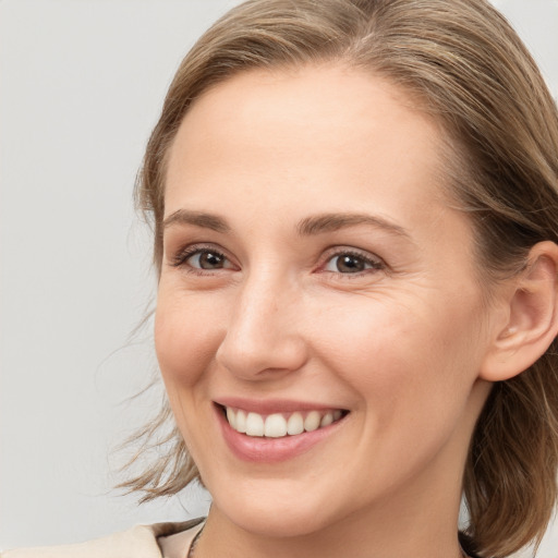 Joyful white young-adult female with medium  brown hair and brown eyes