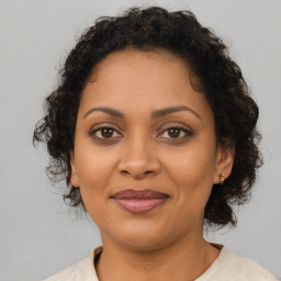 Joyful latino adult female with medium  brown hair and brown eyes