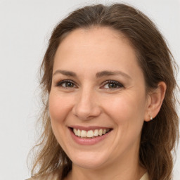 Joyful white adult female with long  brown hair and brown eyes