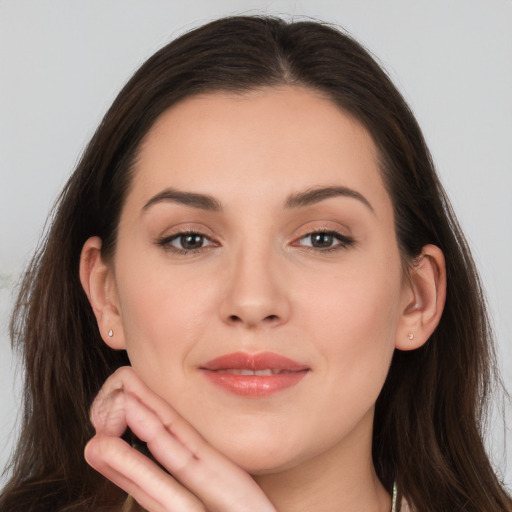 Joyful white young-adult female with long  brown hair and brown eyes