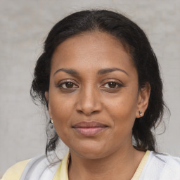 Joyful black adult female with medium  brown hair and brown eyes