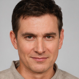 Joyful white adult male with short  brown hair and brown eyes