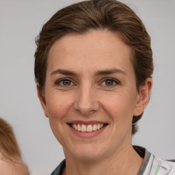 Joyful white adult female with medium  brown hair and brown eyes