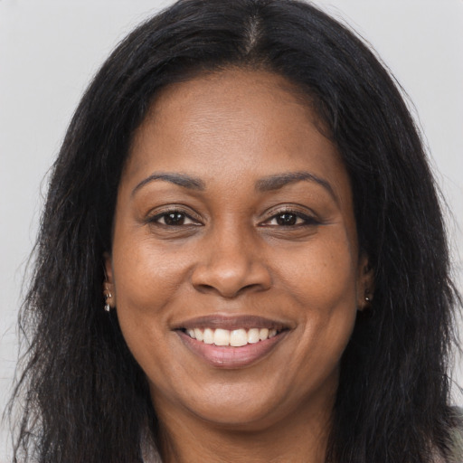 Joyful black adult female with long  brown hair and brown eyes