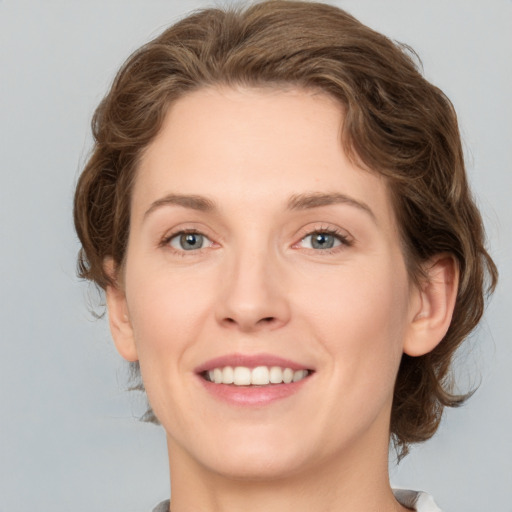 Joyful white young-adult female with medium  brown hair and green eyes