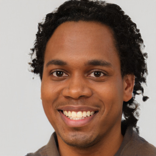Joyful black young-adult male with short  brown hair and brown eyes