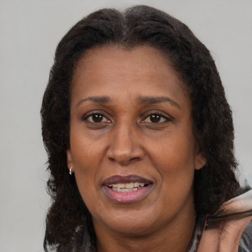 Joyful black adult female with medium  brown hair and brown eyes