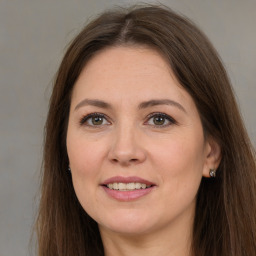 Joyful white adult female with long  brown hair and brown eyes