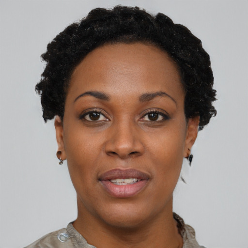 Joyful black young-adult female with short  black hair and brown eyes