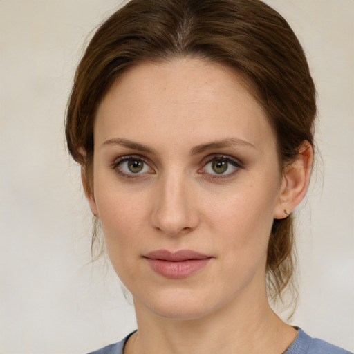 Joyful white young-adult female with medium  brown hair and green eyes