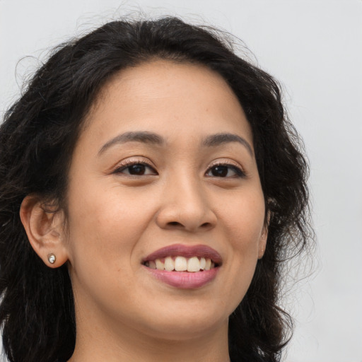 Joyful latino young-adult female with long  brown hair and brown eyes