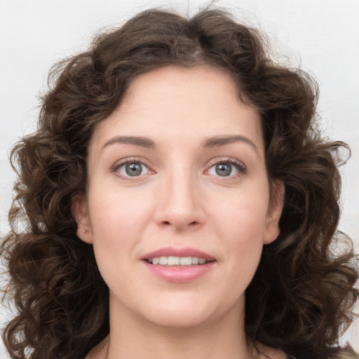 Joyful white young-adult female with long  brown hair and green eyes