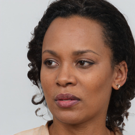 Joyful black young-adult female with medium  brown hair and brown eyes