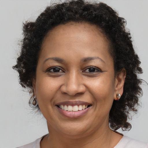 Joyful black adult female with long  brown hair and brown eyes