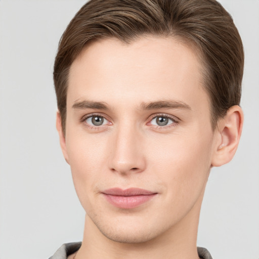 Joyful white young-adult male with short  brown hair and grey eyes