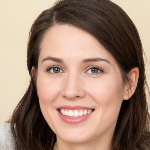 Joyful white young-adult female with long  brown hair and brown eyes