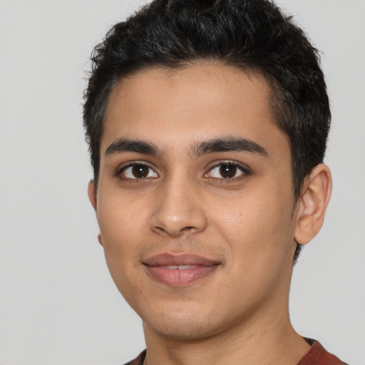 Joyful latino young-adult male with short  black hair and brown eyes