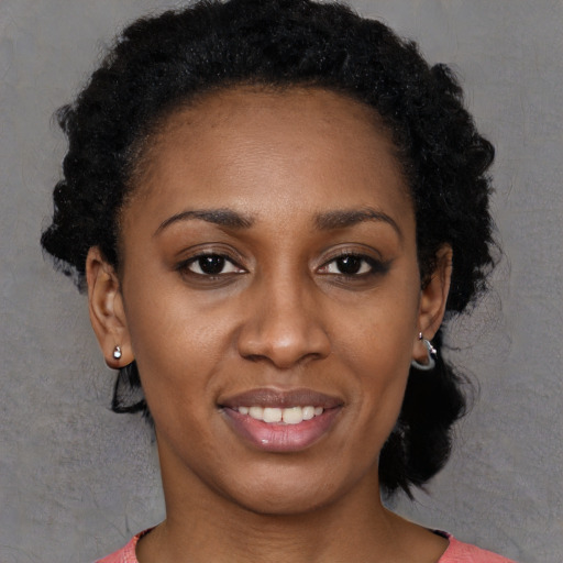 Joyful black young-adult female with short  brown hair and brown eyes