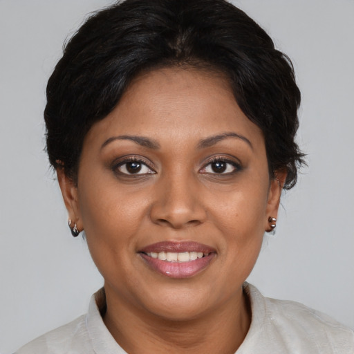 Joyful black adult female with medium  brown hair and brown eyes