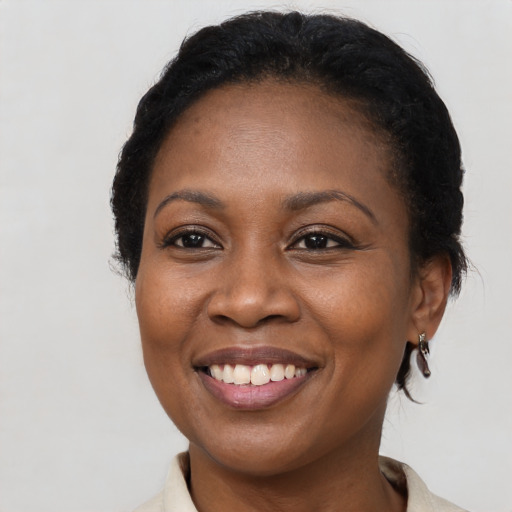 Joyful black adult female with medium  black hair and brown eyes