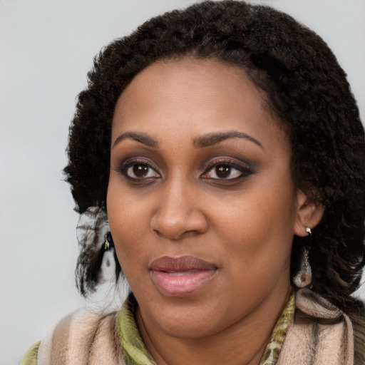 Joyful black young-adult female with long  black hair and brown eyes