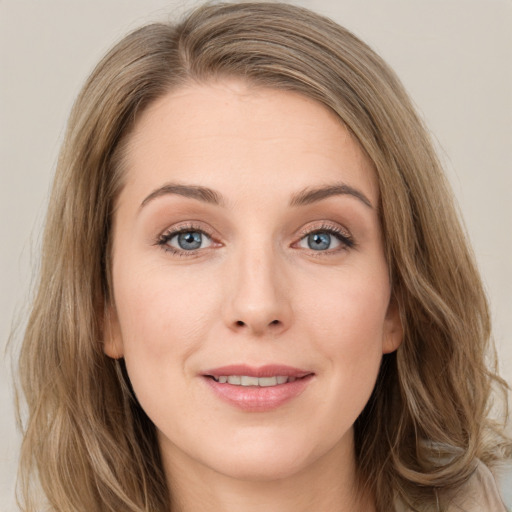 Joyful white young-adult female with long  brown hair and blue eyes