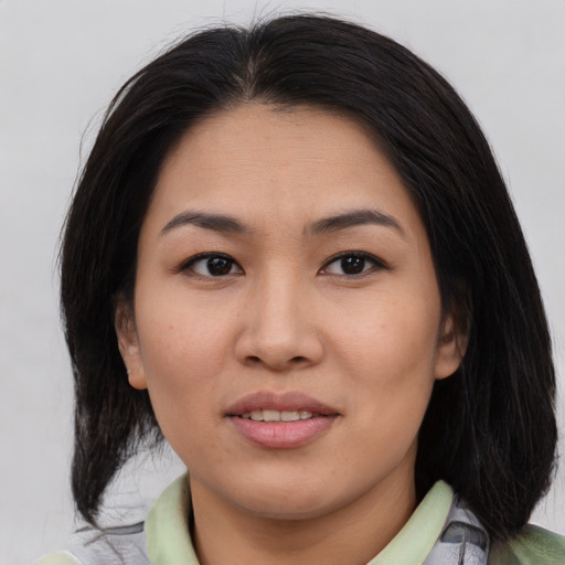 Joyful asian young-adult female with medium  brown hair and brown eyes