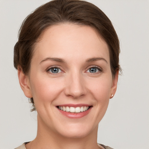 Joyful white young-adult female with short  brown hair and grey eyes