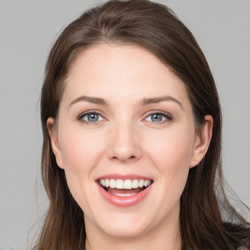 Joyful white young-adult female with long  brown hair and grey eyes