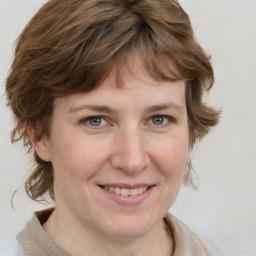 Joyful white adult female with medium  brown hair and blue eyes