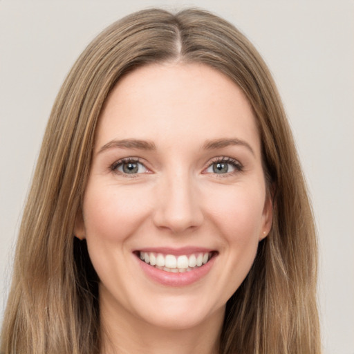 Joyful white young-adult female with long  brown hair and green eyes