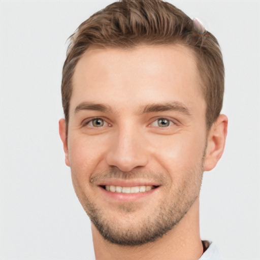 Joyful white young-adult male with short  brown hair and grey eyes