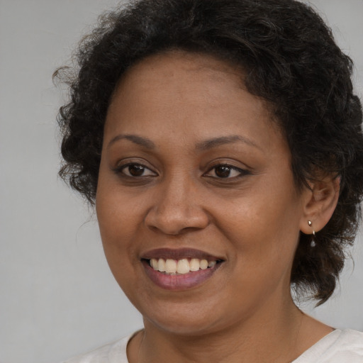Joyful black adult female with medium  brown hair and brown eyes