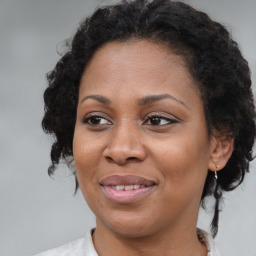 Joyful black adult female with medium  brown hair and brown eyes